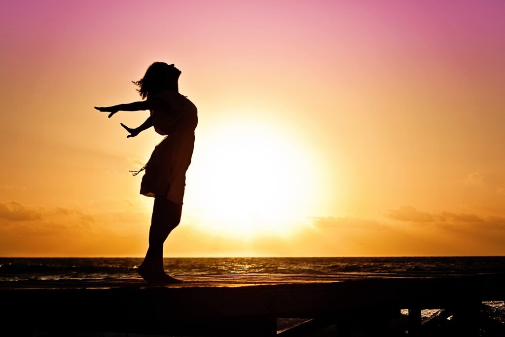 Mujer libre y feliz en un atardecer